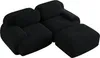 A black modular sofa with an ottoman, shown from a diagonal angle against a white background. Produktbild-Vorschau