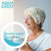 An older woman with glasses smiles while holding a cup, with a circular overlay containing text and a logo. Produktbild-Vorschau