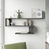 A modern living room with a gray wall-mounted shelf unit displaying decorative items and books. Produktbild-Vorschau