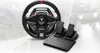 A gaming steering wheel and pedals set is displayed on a background that simulates a race track with blurred cars. Anteprima dell’immagine prodotto