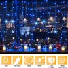 A window decorated with blue LED string lights and snowflake ornaments, with small jars and Christmas trees on the windowsill below. Anteprima dell’immagine prodotto