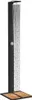A black outdoor shower with water running, standing on a wooden base. Voir les images du produit