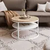 A round coffee table with two shelves is placed on a patterned rug in front of a sofa. Náhľad obrázku produktu