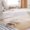 A person is holding a food cover over two bowls of food on a kitchen counter. Produktbild-Vorschau