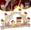 A wooden Christmas arch with illuminated houses and trees, decorated with stars and lights. Náhled obrázku produktu