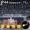 A building decorated with strings of white LED lights at night, with icons indicating weather resistance. Produktbild-Vorschau