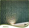 A wall covered with 3D decorative panels, illuminated by a spotlight at the bottom. Podgląd zdjęcia produktu