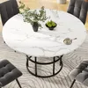 A round dining table with a marble-like top and a black metal base, surrounded by chairs in a dining room setting. Produktbild-Vorschau