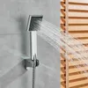 A shower head spraying water in a bathroom setting, with wooden blinds in the background. Náhľad obrázku produktu
