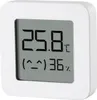 A white digital thermometer and hygrometer with a gray screen displaying temperature and humidity. Voir les images du produit