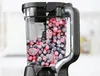 A cutaway view of a blender pitcher filled with frozen berries. Produktbild-Vorschau