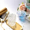 A still life arrangement featuring decorative gel beads in glass containers, alongside flowers and a wine glass. Produktbild-Vorschau