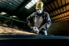 A worker in a factory is using an angle grinder, creating a shower of sparks. Podgląd zdjęcia produktu