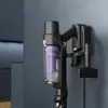 A close-up shot of a black and purple handheld vacuum cleaner mounted on a wall charging dock. Náhled obrázku produktu