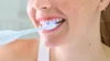 A close-up shot of a person brushing their teeth with an electric toothbrush. Produktbild-Vorschau
