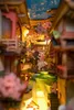 A miniature diorama of a street scene with cherry blossom trees and cartoon-like figures. Náhled obrázku produktu