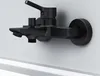 A black bathtub faucet mounted on a white wall. Produktbild-Vorschau