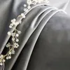 A close-up of a beaded garland draped over gray fabric. Produktbild-Vorschau