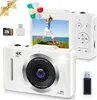 A white digital camera is shown with accessories and a screen displaying a child running on a beach. Balloons are floating above the camera. Produktbild-Vorschau