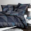 A neatly made bed with a geometric patterned duvet cover and pillows. Produktbild-Vorschau