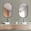 A modern bathroom vanity with two oval mirrors, sinks, and faucets. Produktbild-Vorschau