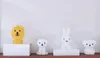 Four decorative lamps shaped like animals (lion, dog, rabbit, bear) are displayed on a shelf against a white wall. Anteprima dell’immagine prodotto