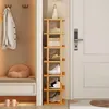 A narrow, tall wooden shoe rack filled with shoes and a few books, placed next to a coat rack and a bench in an entryway. Produktbild-Vorschau