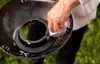 A person's hand is cleaning a black grill part with a sponge and soap. Podgląd zdjęcia produktu