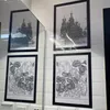 Four framed pictures are displayed on a white tiled wall, with a mirror reflecting two of them. Anteprima dell’immagine prodotto