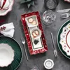 A Christmas-themed table setting with festive dishes, cookies, and cutlery. Anteprima dell’immagine prodotto