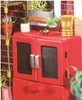 A close-up view of a miniature red cabinet with metallic handles and mesh doors, part of a dollhouse or diorama. Náhled obrázku produktu