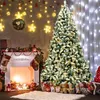 A decorated Christmas tree stands next to a fireplace with stockings hung on it, in a room adorned with festive lights. Produktbild-Vorschau