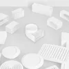 A collection of white plastic ventilation components arranged on a light gray and white surface. Podgląd zdjęcia produktu