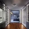 A modern walk-in closet with built-in shelving and lighting, leading to a bedroom visible through a glass door. Produktbild-Vorschau