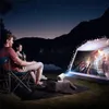 A couple enjoys an outdoor movie night with a projector set up in a tent. Podgląd zdjęcia produktu