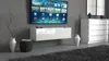 A modern living room with a wall-mounted TV and a white TV stand. Podgląd zdjęcia produktu