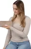 A woman is holding a beige wallet. Produktbild-Vorschau