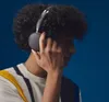 A person wearing headphones and a striped shirt against a blue background. Produktbild-Vorschau