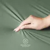 A hand is shown pressing into a soft, green fabric, highlighting its texture and softness. A small butterfly logo and text are visible in the lower right corner. Produktbild-Vorschau