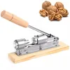 A nutcracker tool and walnuts are shown against a white background. Náhled obrázku produktu