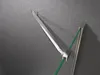 A close-up view of a shower door hinge and support arm attached to a glass panel and a textured wall. Produktbild-Vorschau