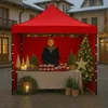 A person standing behind a stall at a Christmas market, selling jars of preserves. Produktbild-Vorschau