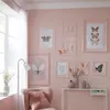 A pink-themed room decorated with butterfly artwork and a plush armchair. Produktbild-Vorschau