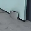 A close-up view of a glass sliding door fitting on a concrete floor. Produktbild-Vorschau
