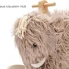 A close-up view of a plush rocking toy shaped like a mammoth, with a wooden handle visible. Produktbild-Vorschau