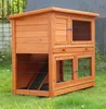 A wooden rabbit hutch with multiple levels, set up outdoors on a grassy lawn. Produktbild-Vorschau