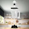 An exploded view of an electric citrus juicer, showing its individual components suspended in the air against a blurred kitchen background. Produktbild-Vorschau