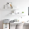 A clean, minimalist home office setup with floating shelves and a desk. Produktbild-Vorschau