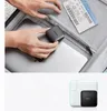 Hands placing a compact charger into a suitcase next to a laptop and a boarding pass. Anteprima dell’immagine prodotto