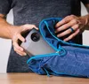 A person is putting a projector into a blue bag. Náhled obrázku produktu